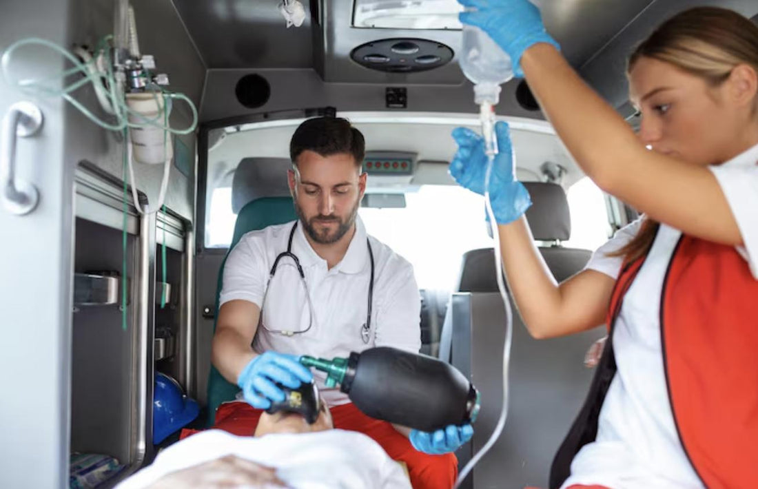EMTs assisting a patient on a stretcher inside the back of an ambulance