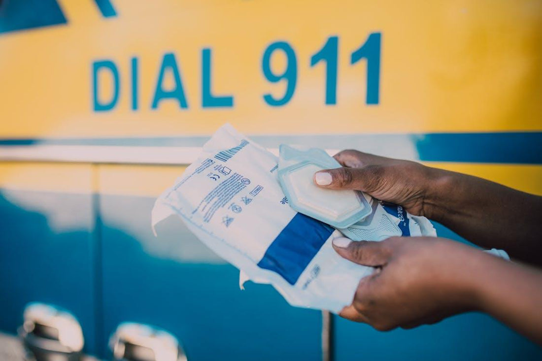 Paramedic holding emergency medical supplies with an ambulance in the background