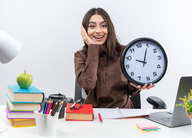 A student preparing for the NREMT paramedic exam holding a wall clock.
