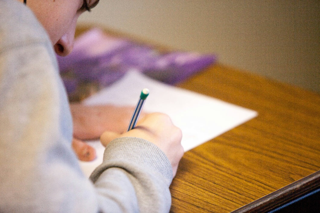 A person using pen and paper for prep.