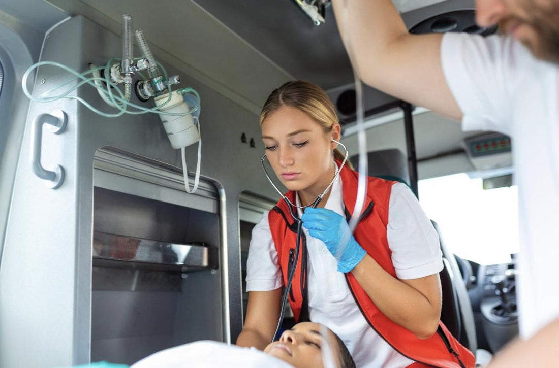 EMT providing emergency care to a patient on a stretcher inside an ambulance