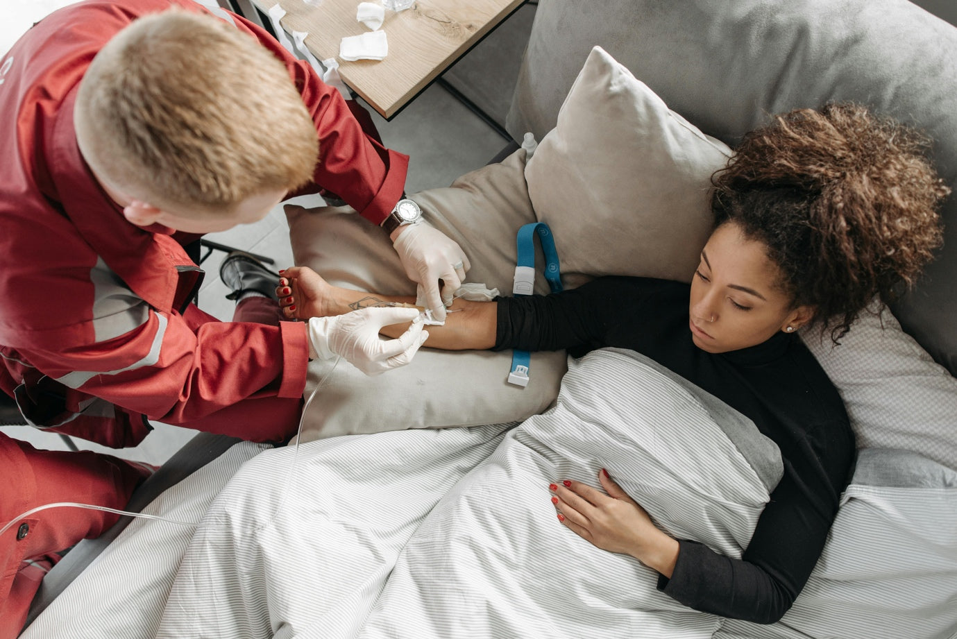 An EMT in uniform caring for a sick woman.