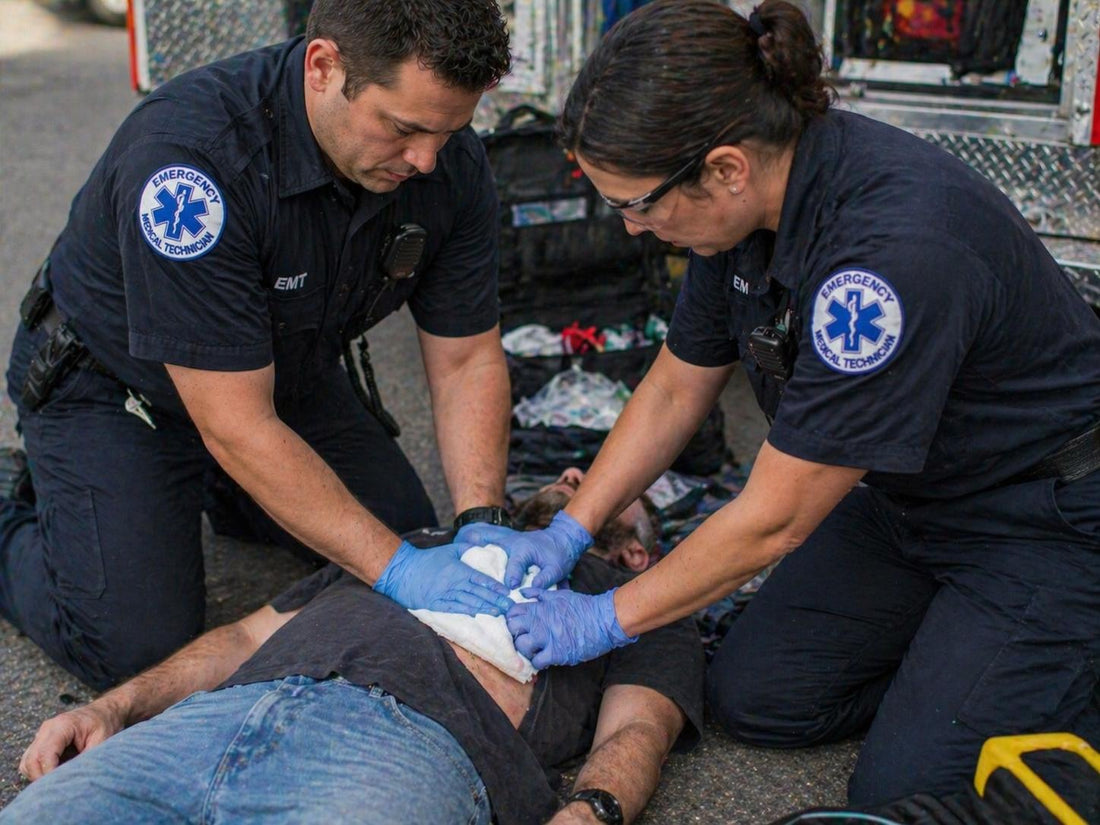 EMT applying firm direct pressure to a bleeding wound on a trauma patient at the scene