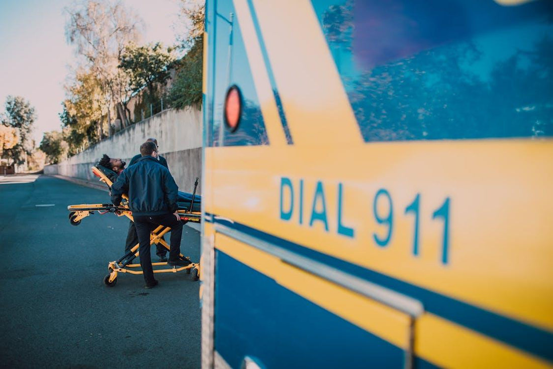A patient lying on a yellow stretcher being attended to by EMS professionals