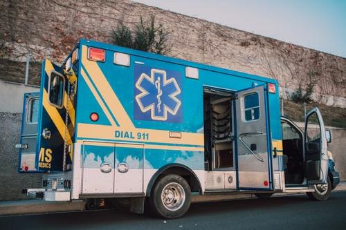 Blue ambulance parked on roadside with open doors