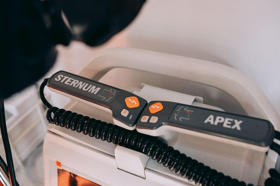 Close-up of a defibrillator showing labeled sternum and apex paddles