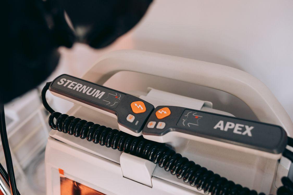 Close-up of a defibrillator showing labeled sternum and apex paddles
