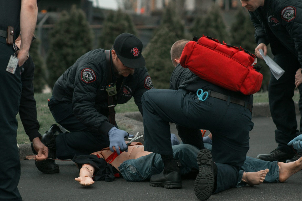 EMS first responders practicing emergency response during an outdoor training simulation