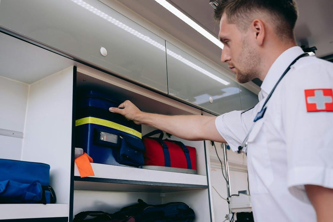 Paramedic taking a medical kit from an ambulance shelf while preparing for an emergency response