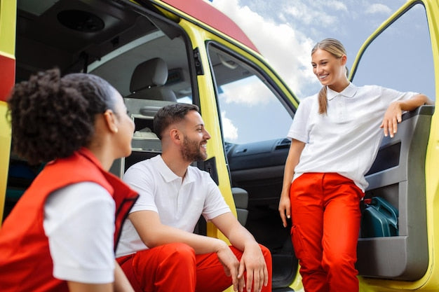 A diverse team of paramedics standing in front of an ambulance.