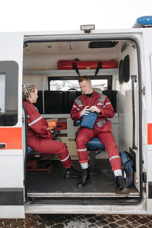 Two paramedics preparing medical equipment inside an ambulance, focused on patient care and emergency readiness
