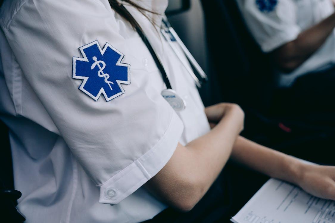 Two paramedics sitting inside an ambulance reviewing patient information and equipment