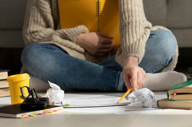 A student preparing for the NREMT exam with books and a notebook.