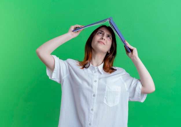 Woman holding a folder over her head, showing signs of exam stress and anxiety.