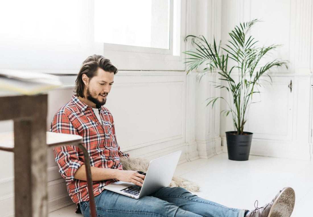 A young man sitting at home, focused on his laptop while studying for the NREMT exam